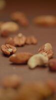 A CloseUp View of a Variety of Mixed Nuts Artistically Arranged on a Wooden Surface video