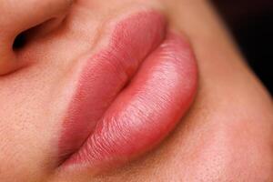 A womans lips one month after permanent makeup. The soft pigment shade gives them a natural and neat look after the healing process. photo