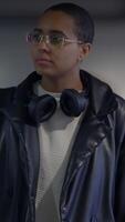 A Stylish Young Individual Posing in an Urban Setting While Wearing Headphones and Attire video