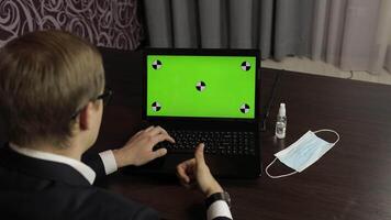 Man are typing on laptop keyboard with green screen, chroma key. Distance work video