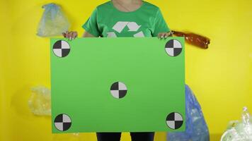 Unrecognizable woman holding chroma key poster with tracking points. Environment plastic pollution video