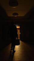 A dimly lit hallway has an open door inviting exploration into the shadows beyond video