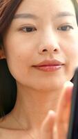 A young woman is smiling joyfully while she is using her smartphone device actively video