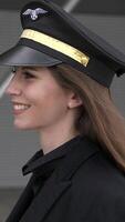 A Pilot Dressed in a Professional Uniform with a Cap is Smiling Outside Amidst Nature video
