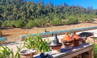 Traditional moroccan tagine pots resting on a wooden table in the atlas mountains photo
