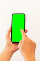 women hand holding smart mobile phone with blank green screen on isolated white background photo