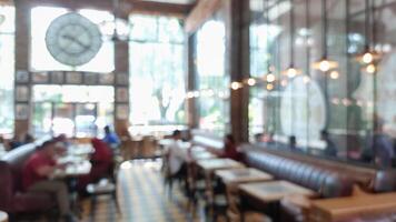 Blurry background of restaurant with light bulb hanging and large window. Customer is waiting for food photo