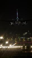 A nighttime landing procedure of an airplane occurs at a busy and bustling airport video