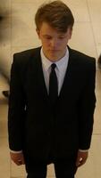 A Young Man Dressed in a Suit with a Pensive and Thoughtful Expression on His Face video