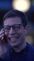 A Joyful Man Laughing Heartily on the Phone While Attending a Nighttime Event Celebration video