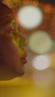 This contemplative profile is set against a backdrop of vibrant bokeh lights at night video