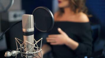 Professional microphone in the recording studio. Background of a singing woman. video