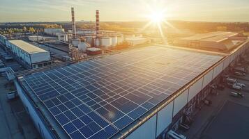 Large industrial building using solar panels on rooftop at sunset photo