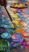 Painter picking up orange oil paint with brush from palette photo