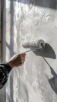 Construction worker painting a wall with gray paint photo