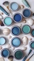 Painting supplies and seashells forming a creative flat lay photo