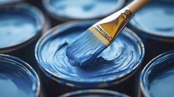 Paintbrush dipping in blue paint can for home improvement project photo