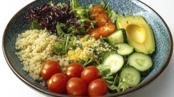Colorful nutritious salad bowl with quinoa, tomatoes, avocado and cucumber photo