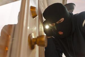 Masked burglar picking lock and breaking into house photo