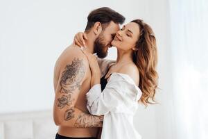 Happy passionate young couple in underwear kissing and enjoying foreplay, hugging photo