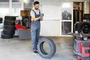 Mechanic wearing overalls putting gloves on in a garage photo