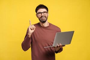 Handsome, smiling bearded hispanic man, freelancer, programmer using laptop, showing finger up photo
