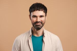 Portrait of smiling, happy Latin man looking at camera, posing isolated on beige background photo