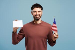 Portrait of happy man holding American flag and empty, blank mockup, copy space looking at camera photo