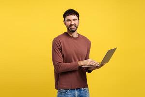 Portrait of smiling bearded man, successful freelancer using laptop, copywriter typing on keyboard photo