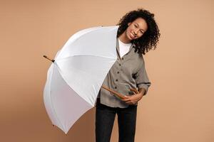 Smiling young African American woman with white umbrella looking at camera isolated photo