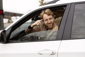 Skeptical driver pointing at his head while sitting in car photo