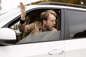 Angry driver shouting and gesturing from car window photo