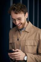 Happy businessman using smartphone app for texting on blue background photo