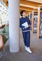 Thoughtful university student planning next class in library photo
