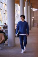Happy college student walking in university hallway photo