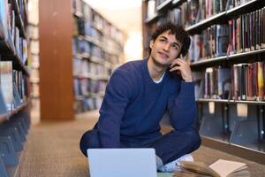 Thoughtful student researching and brainstorming in university library photo