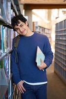 Young student relaxing in the library between classes photo