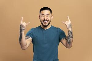 Young man making rock and roll gesture with both hands photo