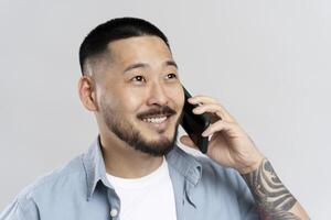Smiling young man talking on mobile phone having pleasant conversation photo