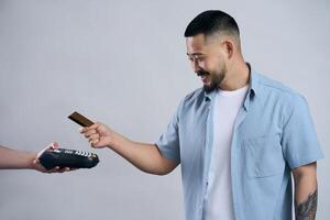Happy customer making a payment using a credit card and a pos terminal photo