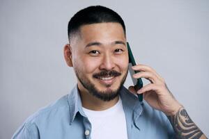 Asian man smiling while talking on the phone photo