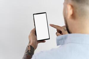 Man pointing at smartphone with white screen photo