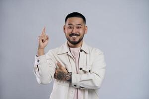 Young man having an idea is pointing up with a smile photo