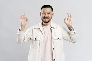 Happy man showing ok sign with both hands is smiling at camera photo