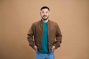 Young man smiling with hands in pockets is feeling confident photo