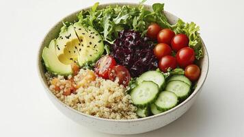 Bowl containing quinoa, sliced avocado, and chopped vegetables photo