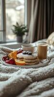 Delicious breakfast with pancakes and coffee served on bed on cozy winter day photo