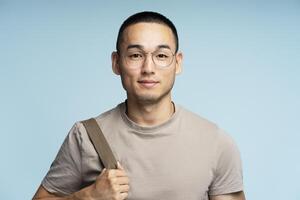 Confident student posing with backpack on blue background photo