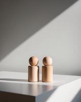 Two wooden figurines on a white surface photo