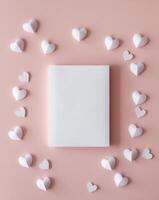 White paper hearts on pink background with blank space for text photo
